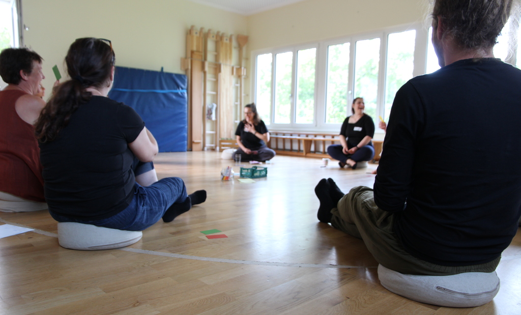 Sitzkreis mehrer Menschen bei einem Workshop